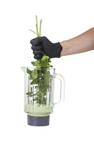 hand holding herbs in a mixerの写真素材