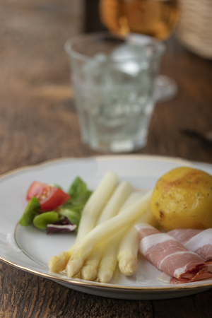 cooked white asparagus with ham and potatoの写真素材