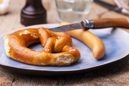 pretzel with frankfurt sausage on a plateの写真素材