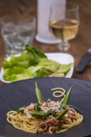 spaghetti with tomato sauce on a black plateの写真素材