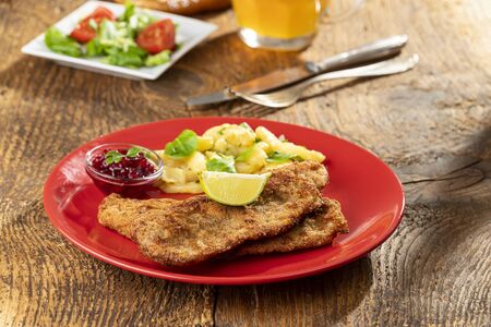 wiener schnitzel with potato salad on a plateの写真素材