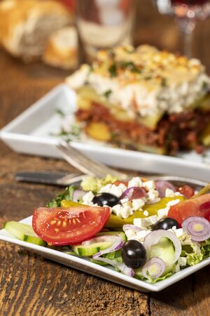 greek salad with moussaka on woodの写真素材