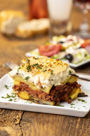 portion of greek moussaka on woodの写真素材