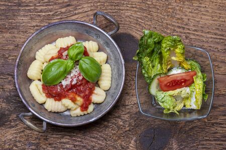 closeup of gnocchi with sauce on woodの写真素材