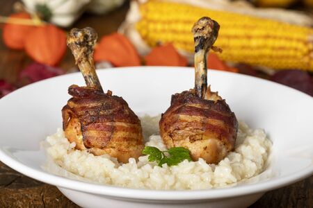 chicken legs with bacon on risottoの写真素材