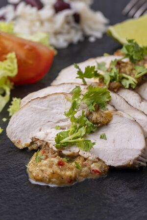 slices of a grilled chicken on slateの写真素材