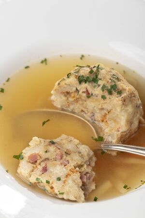 single speckknoedel in soup on woodの写真素材