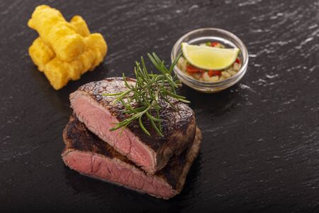 slices of grilled steak on black slateの写真素材