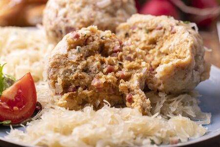 two speckknoedel with sauerkraut on wood の写真素材