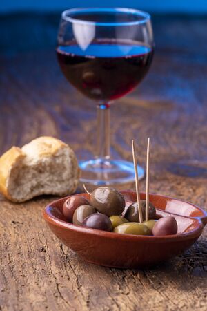 mixed olives on dark wood の写真素材