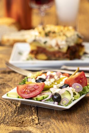greek salad with moussaka on woodの写真素材
