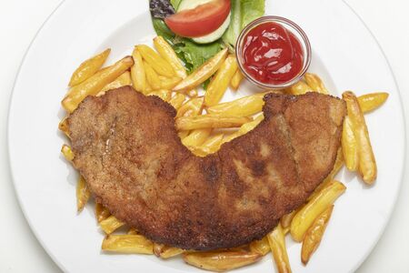 wiener schnitzel with french fries on a plateの写真素材
