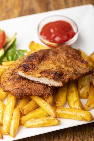 wiener schnitzel with french fries on a plateの写真素材