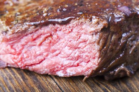 slices of a steak on wood with rosemaryの写真素材
