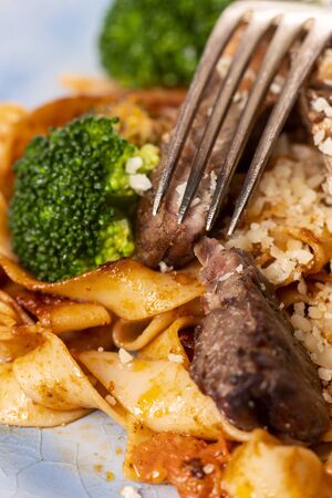 tagliatelli with steak slices on a plateの写真素材