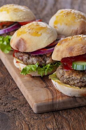 four small hamburges on a boardの写真素材