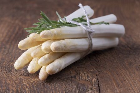 bunch of white asparagus on woodの写真素材