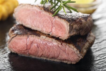 slices of grilled steak on black slateの写真素材