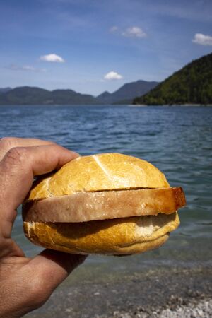 hand holding a meat loaf bun at Walchenseeの写真素材