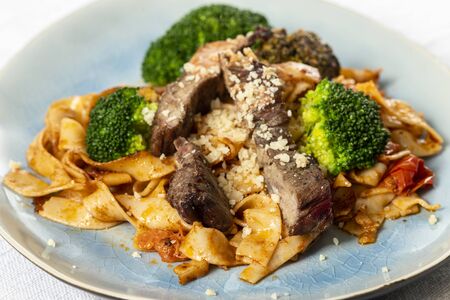 tagliatelli with steak slices on a plateの写真素材