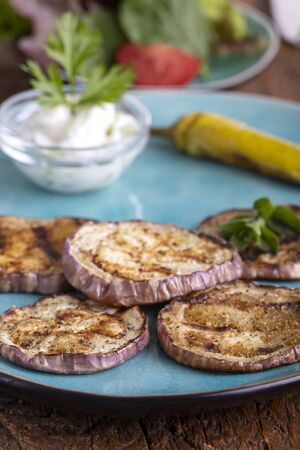 grilled eggplant with tsatsiki on woodの写真素材