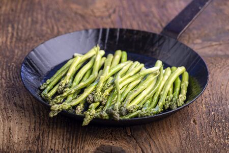 green asparagus in an iron panの写真素材