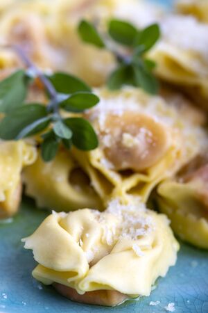 tortellini with olive oil on a blue plateの写真素材