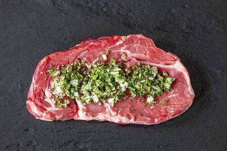 overview of a raw steak on black sliceの写真素材