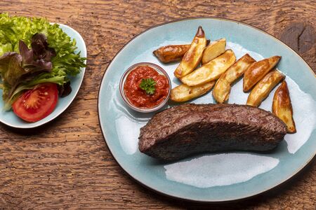 grilled steak with frech fries on woodの写真素材