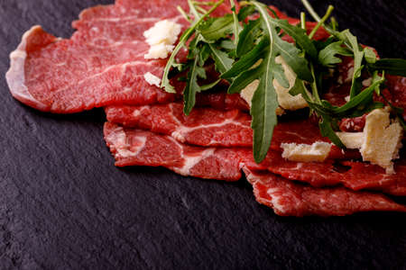 fresh carpaccio with arugula on slateの写真素材