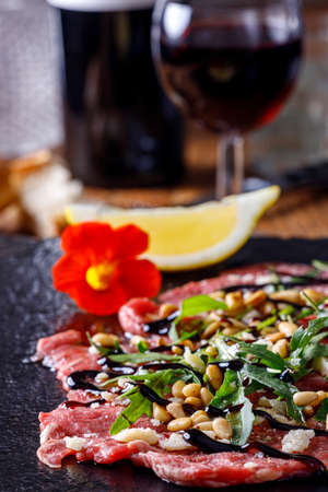 fresh carpaccio with arugula on slateの写真素材