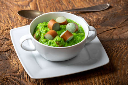 creamy pea soup on dark woodの写真素材