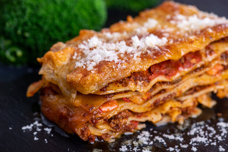 Lasagna on slate with broccoliの写真素材