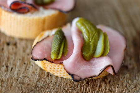 Ham sandwich with gherkin on woodの写真素材