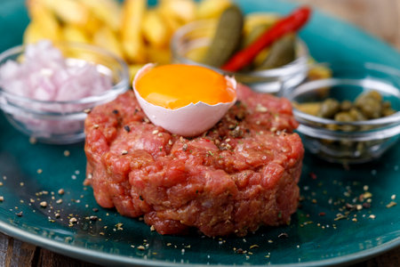 Steak tartare with open egg on woodの写真素材