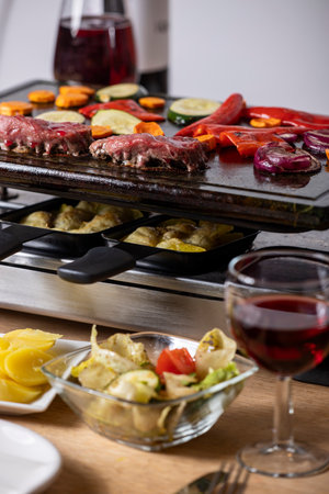 Swiss raclette with meat and vegetablesの写真素材