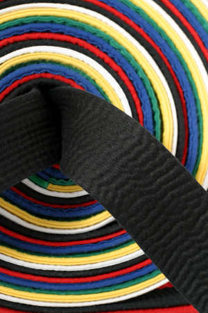 Martial Arts - Close-up on the black belt with the other belt colors used as a backgroundの写真素材