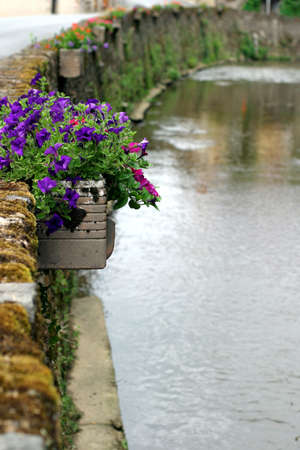 Riverside Jardiniere - charming French Perigord village with colorful petunias along the stone wall.の写真素材