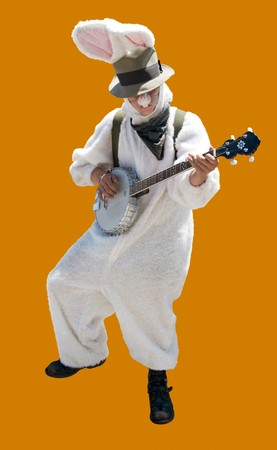 Easter Bunny Playing Banjo. A street musician in a white rabbit costume at work. Isolated on orange, path included.の写真素材