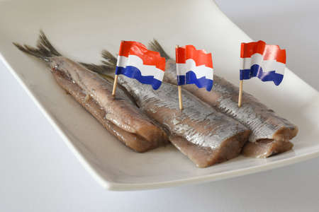 Den Helder, Netherlands. June 2022. Fresh raw herring on a white plate. Isolated. selective focus. High quality photoの写真素材