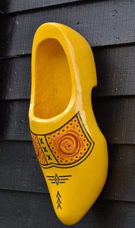 Colorful clogs against the background of a wooden wall. Popular souvenirs. Traditions of Holland....