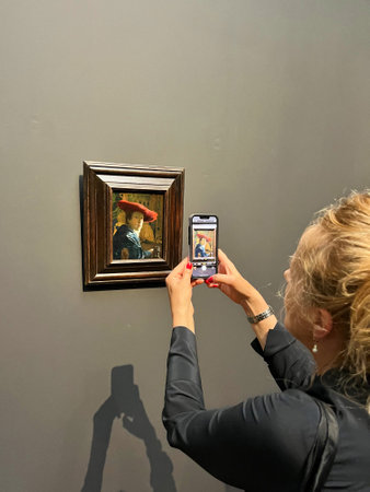 Amsterdam, Netherlands. August 6, 2023. A visitor taking pictures of famous paintings. . High quality photoのeditorial素材