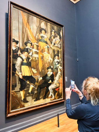 Amsterdam, Netherlands. August 6, 2023. A visitor taking pictures of famous paintings. . High quality photoのeditorial素材