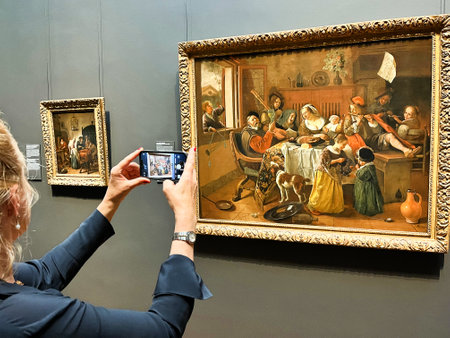 Amsterdam, Netherlands. August 6, 2023. A visitor taking pictures of famous paintings. . High quality photoのeditorial素材