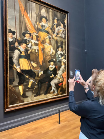 Amsterdam, Netherlands. August 6, 2023. A woman takes a picture of world-famous painting at the Rijksmuseum Amsterdam. High quality photoのeditorial素材