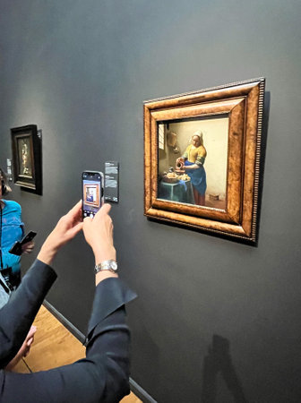 Amsterdam, Netherlands. August 6, 2023. A woman takes a picture of world-famous painting at the Rijksmuseum Amsterdam. High quality photoのeditorial素材
