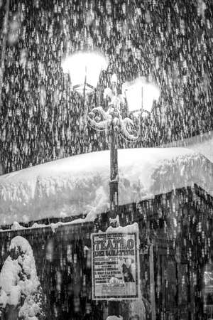 Snow covers a lamppost in an alpine village of Italian Alps.の写真素材