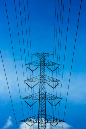 Electric power high voltage transmission line pylon tower on blue sky and white cloud backgroundの写真素材