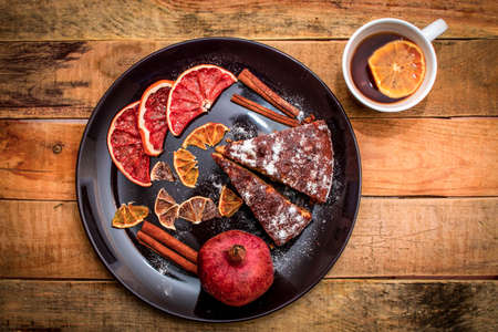 dessert with pomegranate and cinnamon on a black plateの写真素材