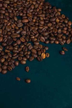 grains of fragrant coffee are scattered over the dark wooden background of the tableの写真素材